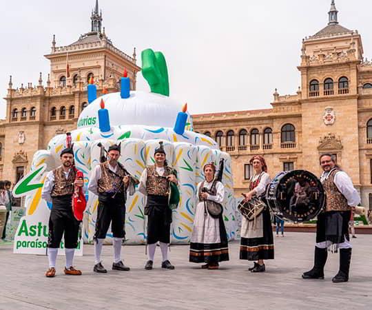 Grupo de gaiteros posando delante de la tarta inchable conmemorativa de los 40 años de la marca Asturias paraíso natural.